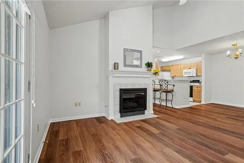 a view of empty room with wooden floor and fireplace
