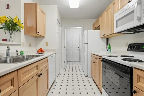 a kitchen with granite countertop a sink stove and cabinets