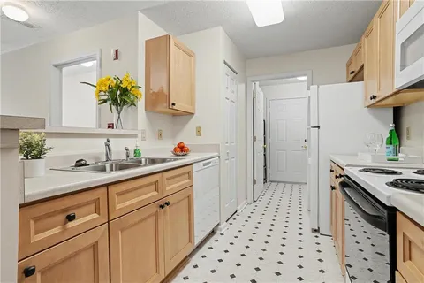a kitchen with a sink a stove cabinets and wooden floor