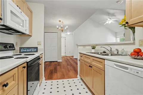 a kitchen with granite countertop a sink stove and cabinets