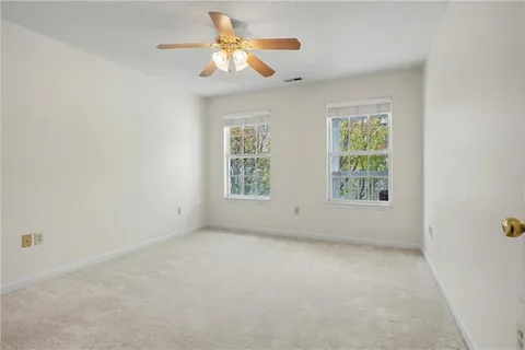 an empty room with a window and a fan
