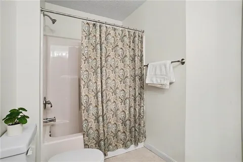 a bathroom with a shower curtain and a toilet