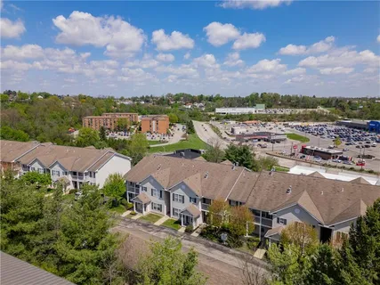 an aerial view of residential houses with outdoor space and city view