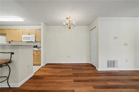a view of a kitchen with wooden floor and a ceiling fan