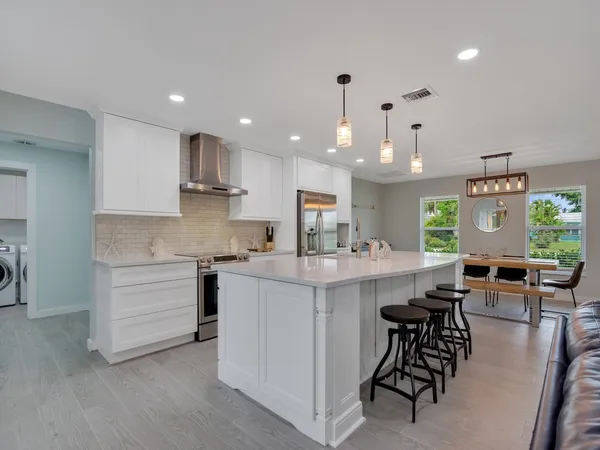 a kitchen with cabinets and chairs
