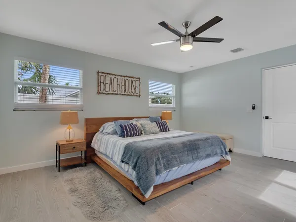 a spacious bedroom with a bed and a ceiling fan