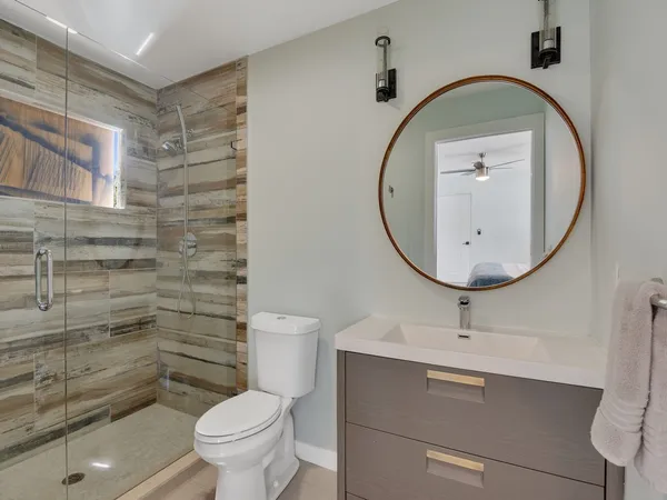a bathroom with a toilet a sink and a mirror