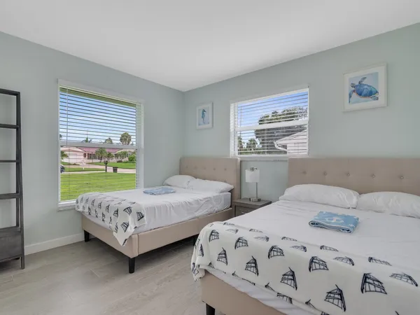 a bedroom with two beds and a large window