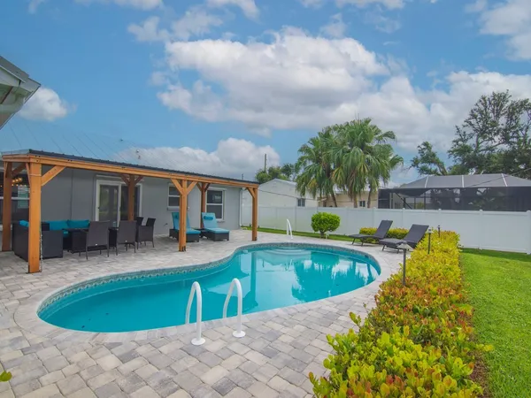 a view of a house with swimming pool and sitting area