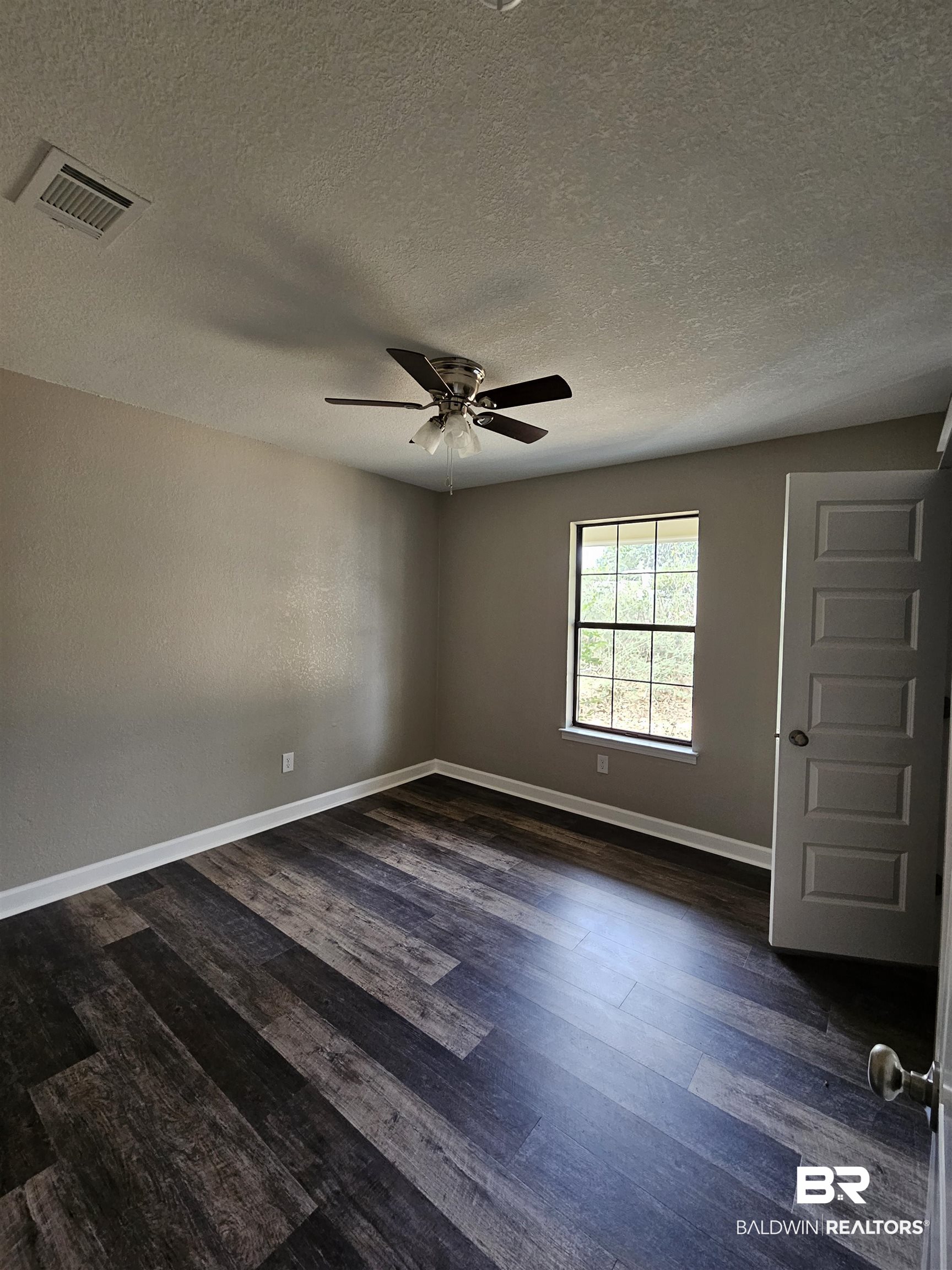 138 Wicker Way Daphne, AL 36526 - Photo 20 of 32 Unfurnished room featuring dark wood-style floors, a ceiling fan, and a textured ceiling