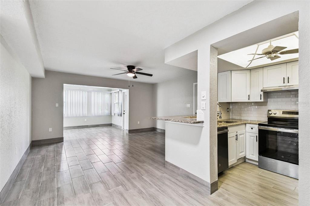 4726 Marine Parkway, Unit 103 New Port Richey, FL 34652 - Photo 12 of 81 a kitchen with stainless steel appliances granite countertop a stove top oven a sink and white cabinets
