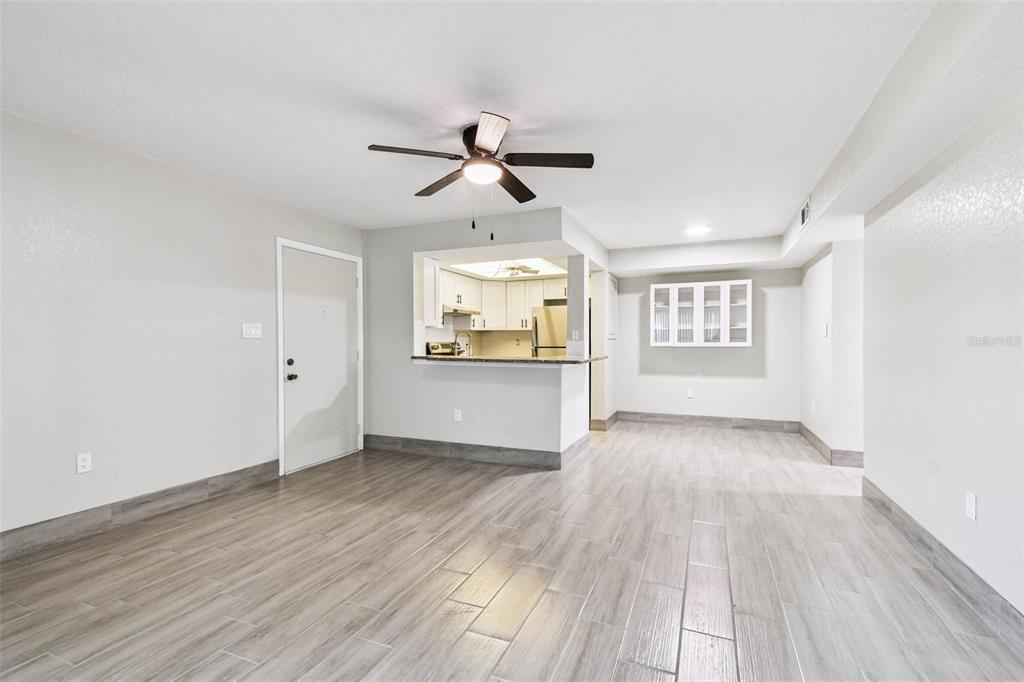 4726 Marine Parkway, Unit 103 New Port Richey, FL 34652 - Photo 14 of 81 an empty room with wooden floor ceiling fan and windows