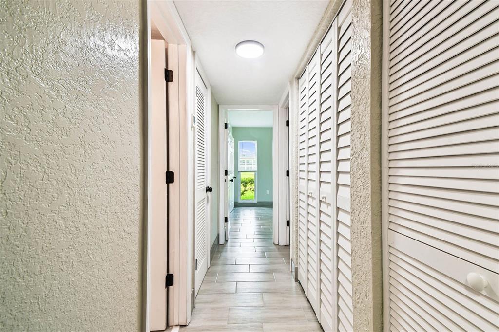 4726 Marine Parkway, Unit 103 New Port Richey, FL 34652 - Photo 22 of 81 a view of a hallway with wooden floor and a bathroom