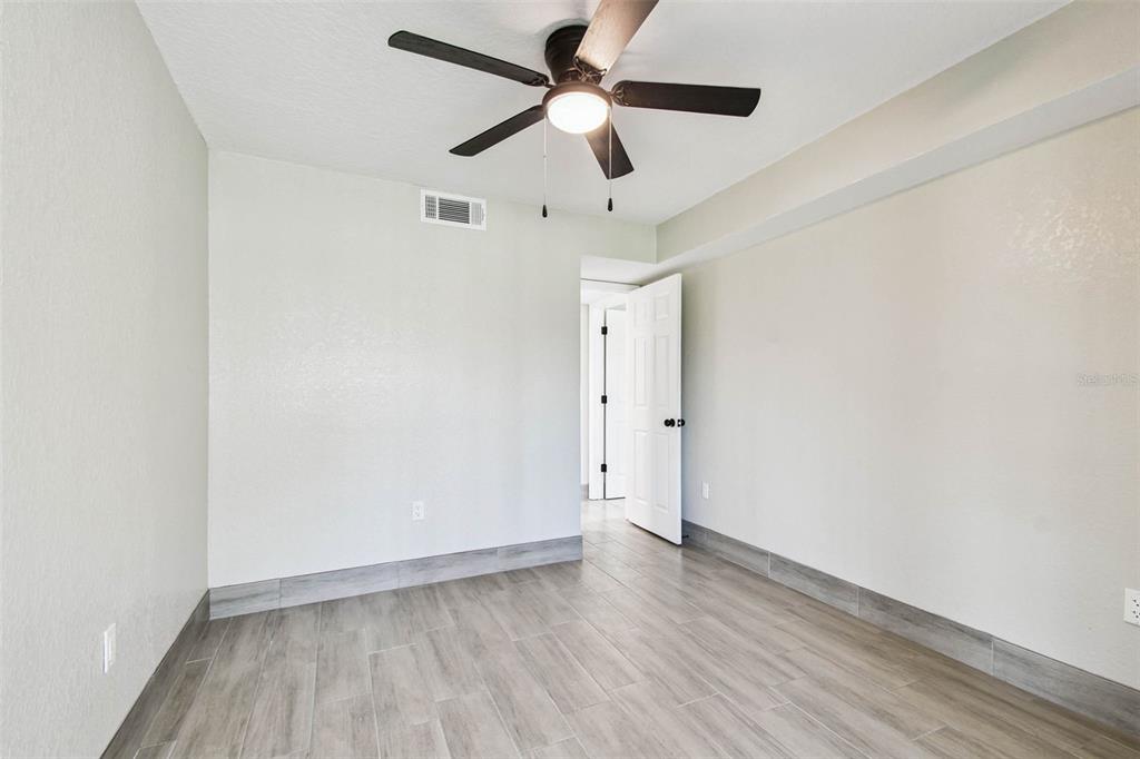 4726 Marine Parkway, Unit 103 New Port Richey, FL 34652 - Photo 28 of 81 an empty room with wooden floor ceiling fan and window