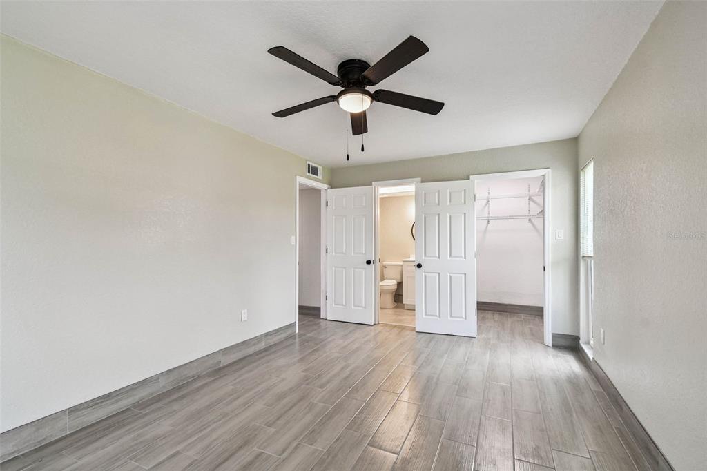 4726 Marine Parkway, Unit 103 New Port Richey, FL 34652 - Photo 34 of 81 an empty room with wooden floor and ceiling fan