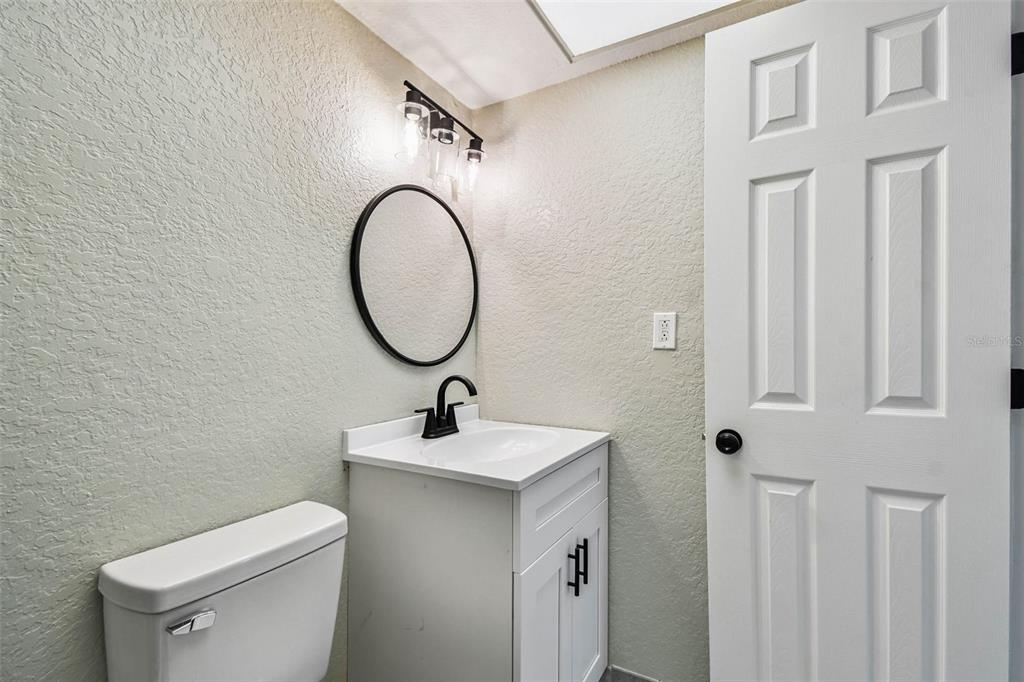 4726 Marine Parkway, Unit 103 New Port Richey, FL 34652 - Photo 41 of 81 a bathroom with a sink a toilet and a mirror