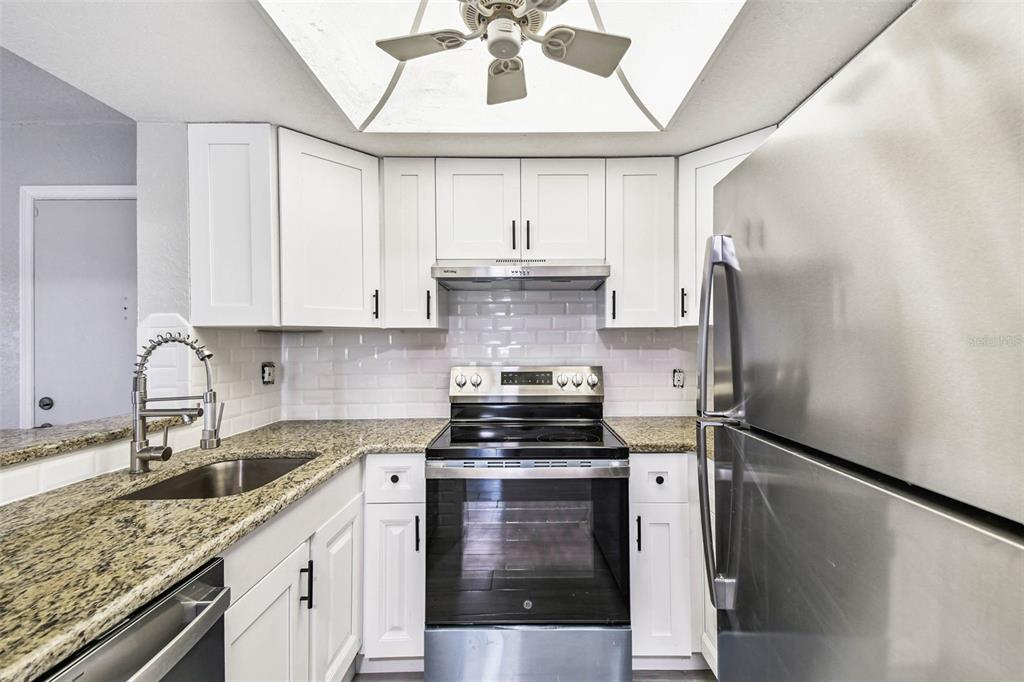 4726 Marine Parkway, Unit 103 New Port Richey, FL 34652 - Photo 7 of 81 a kitchen with stainless steel appliances granite countertop a sink stove and refrigerator