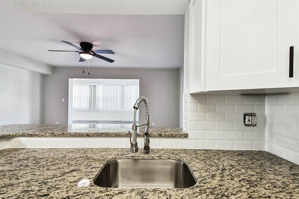 4726 Marine Parkway, Unit 103 New Port Richey, FL 34652 - Photo 9 of 81 a kitchen with granite countertop a sink and a stove