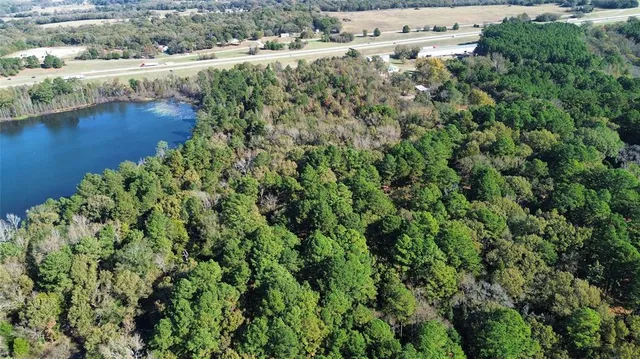 an aerial view of residential houses with outdoor space and trees all around