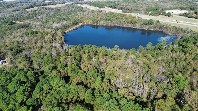 an aerial view of a house with a yard and lake view