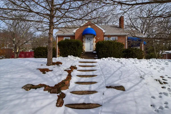 a view of a house with a yard covered in snow