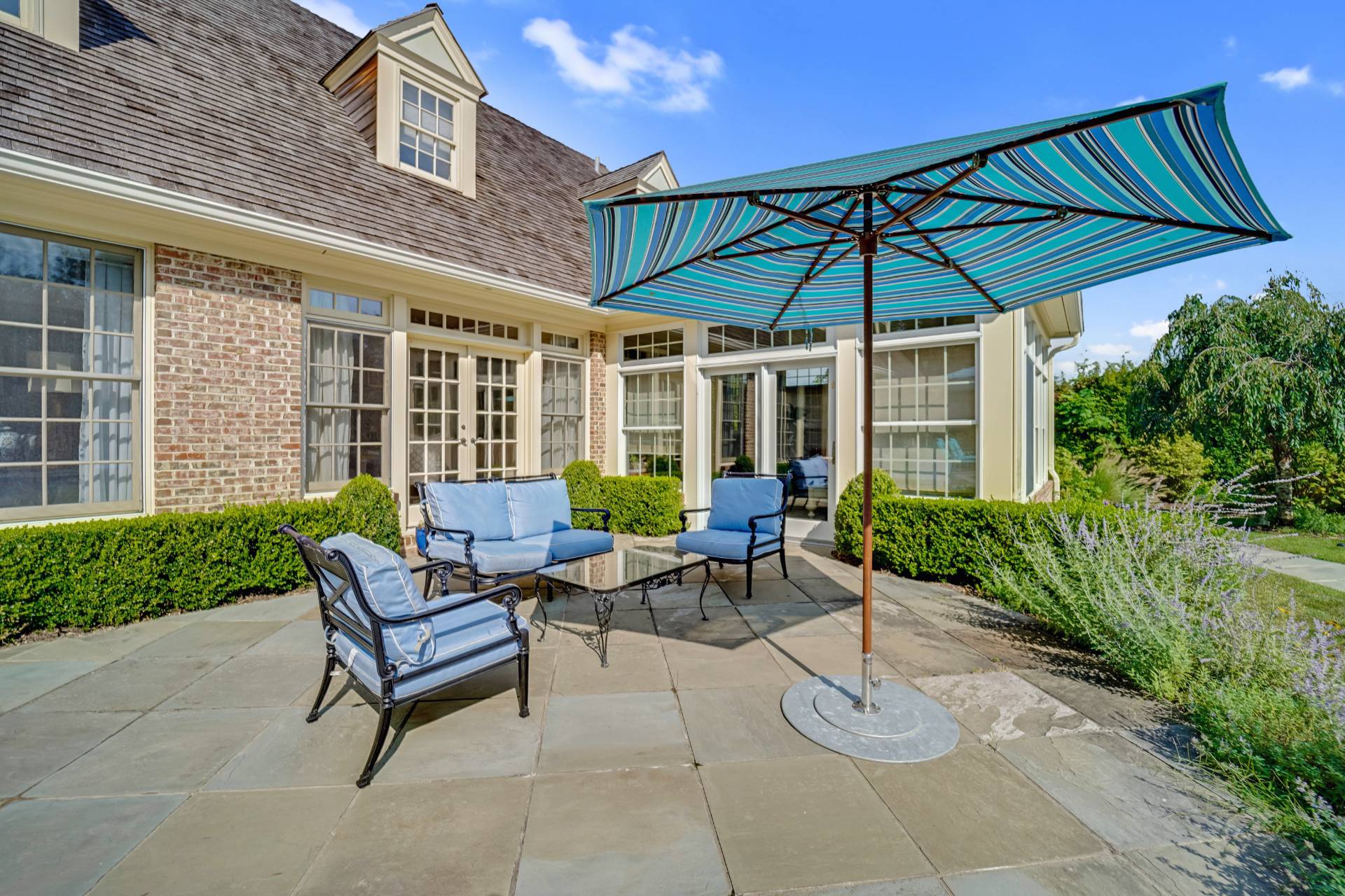 53 South Road Westhampton Beach, NY 11978 - Photo 24 of 28 a view of a patio with a table and chairs under an umbrella