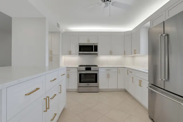 a kitchen with granite countertop white cabinets white stainless steel appliances with a sink and dishwasher