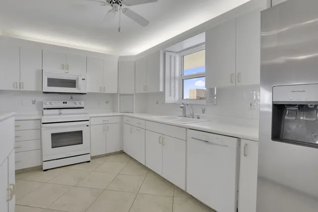 a kitchen with sink a microwave and cabinets