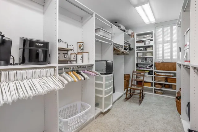 a view of walk in closet with clothes and shoes