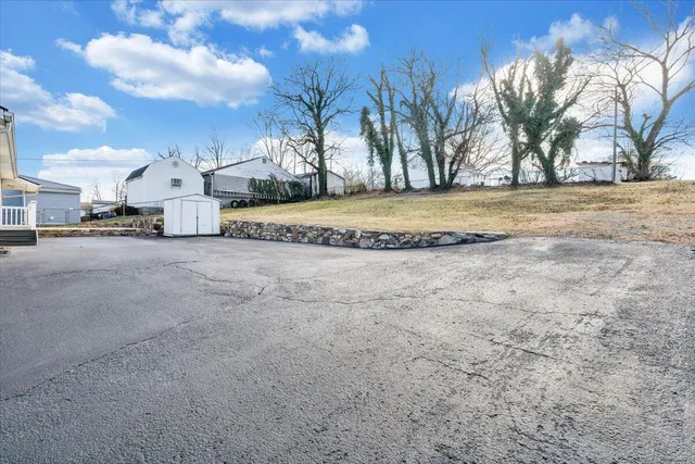 a front view of a house with a garden and trees