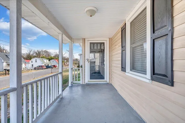 a view of a porch with wooden floor and floor to ceiling window