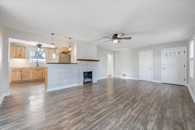 a view of a kitchen with wooden floor and a sink