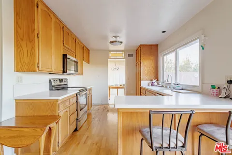 a view of a kitchen with kitchen island granite countertop a sink and a stove top oven