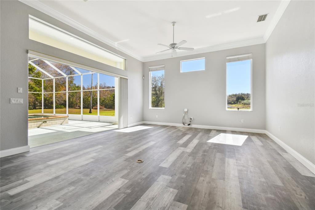 6644 Country Club Road Wesley Chapel, FL 33544 - Photo 12 of 75 a view of an empty room with a window and wooden floor