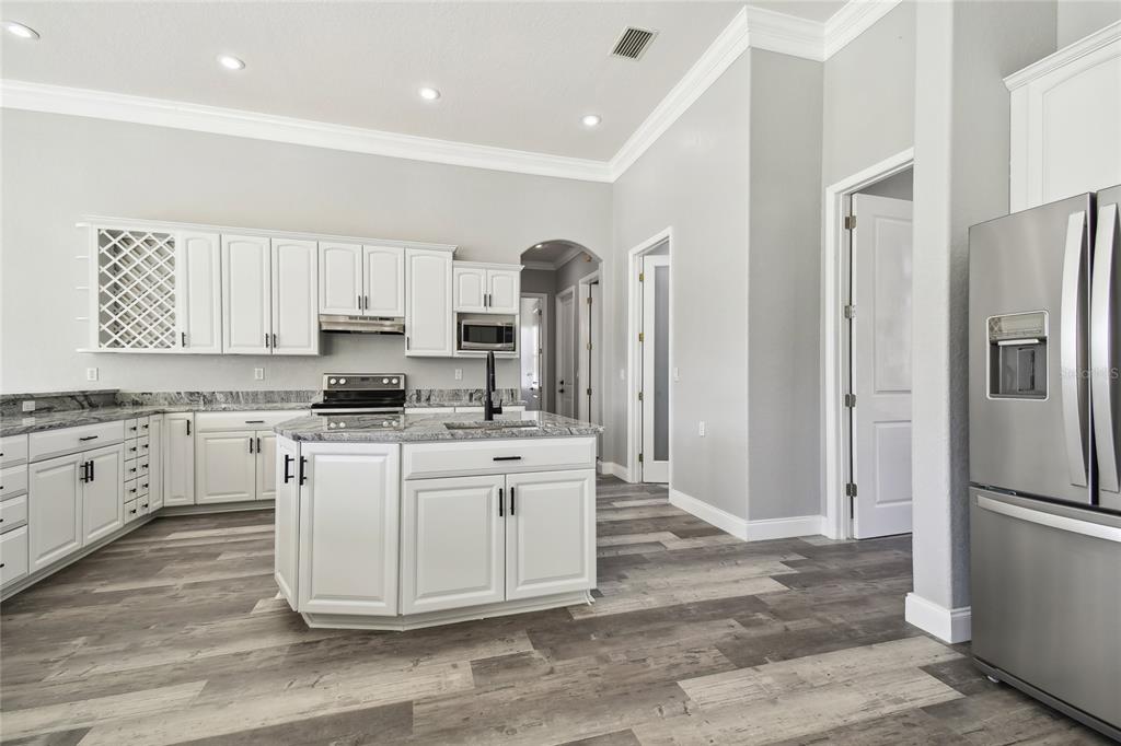 6644 Country Club Road Wesley Chapel, FL 33544 - Photo 16 of 75 a kitchen with stainless steel appliances granite countertop a refrigerator sink and stove