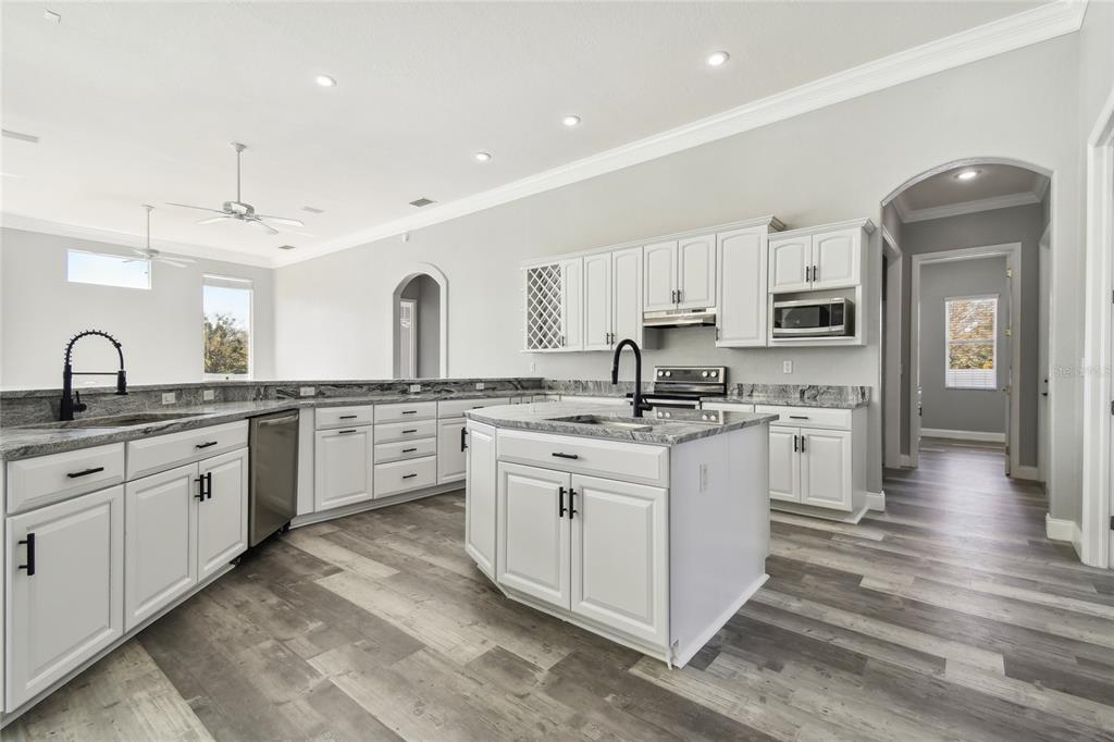 6644 Country Club Road Wesley Chapel, FL 33544 - Photo 17 of 75 a kitchen with granite countertop white cabinets and white appliances
