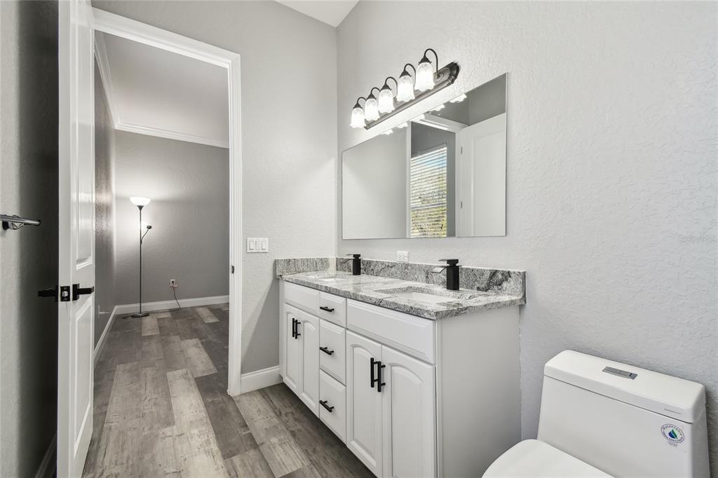 6644 Country Club Road Wesley Chapel, FL 33544 - Photo 53 of 75 a bathroom with a toilet sink and mirror