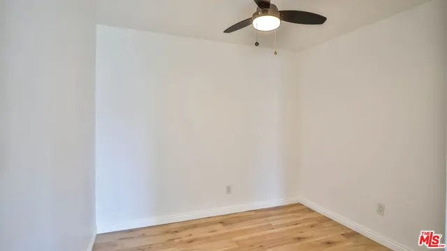 a view of a room with wooden floor and fan