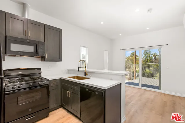 a kitchen with a sink stove and microwave