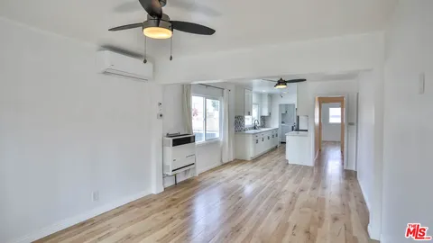 a large kitchen with a wooden floor stainless steel appliances and cabinets
