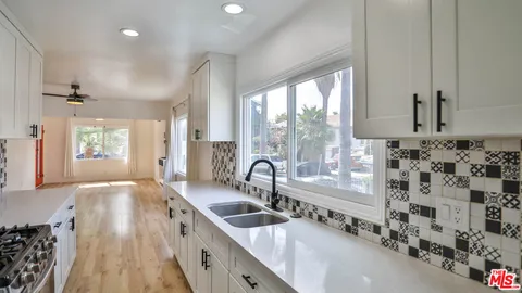 a large kitchen with granite countertop a large window and a sink