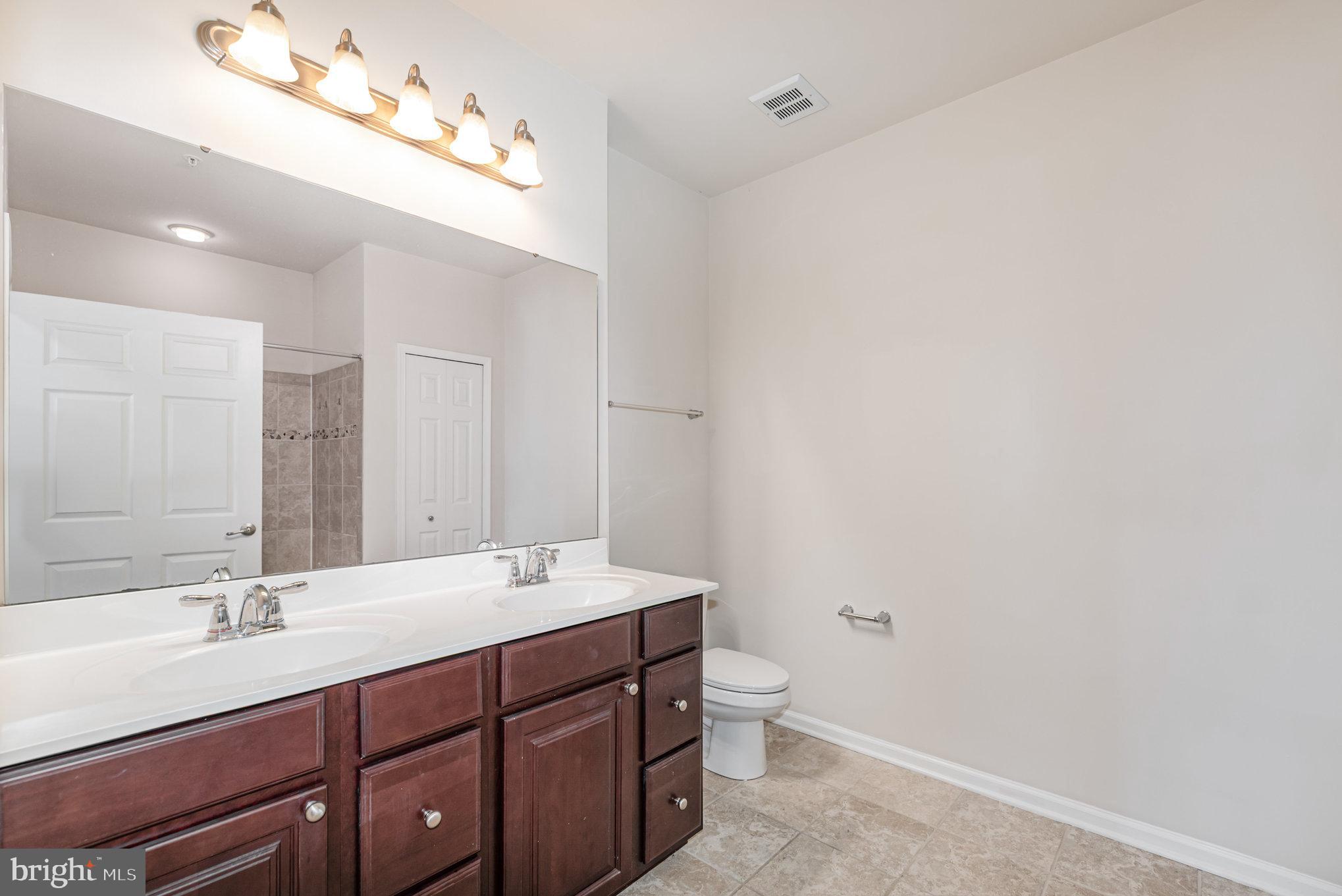 1624 Hardwick Court, Unit 402 Hanover, MD 21076 - Photo 16 of 27 a bathroom with a double vanity sink and a mirror