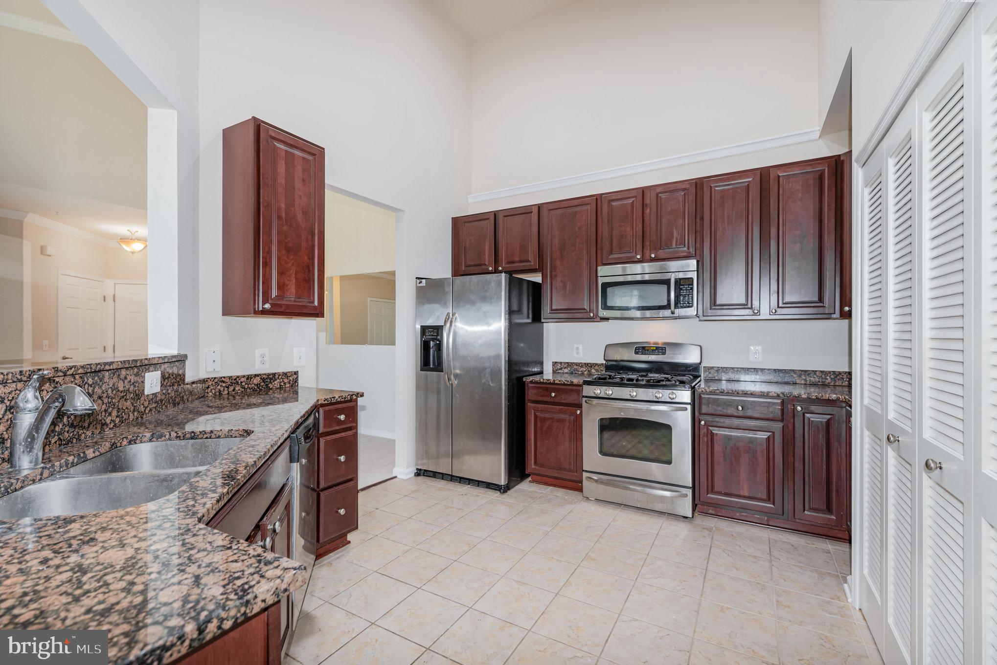 1624 Hardwick Court, Unit 402 Hanover, MD 21076 - Photo 8 of 27 a kitchen with stainless steel appliances granite countertop a sink stove and refrigerator