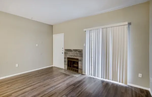 a view of a livingroom with wooden floor and a fireplace