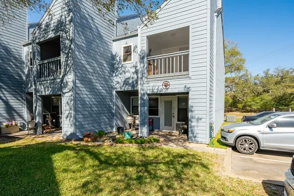 a view of a house with a yard and lawn chairs