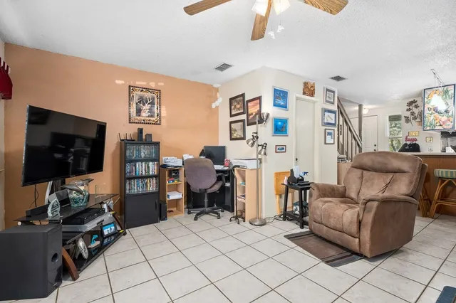 a living room with furniture a flat screen tv and gym equipment