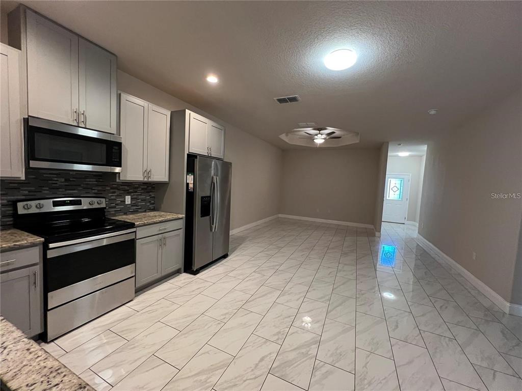 11 Ullock Place, Unit A Palm Coast, FL 32164 - Photo 3 of 10 a kitchen with stainless steel appliances granite countertop a refrigerator and a stove top oven