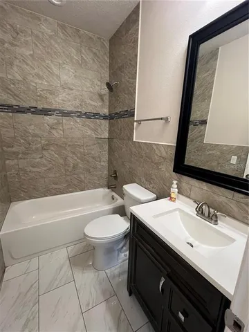 a bathroom with a sink a toilet a mirror and bathtub