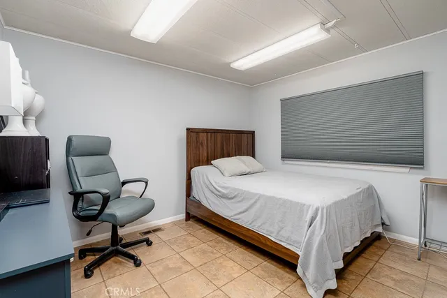 a bedroom with a bed window and chair