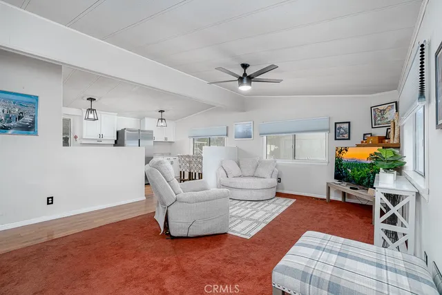 a living room with furniture a chandelier and a rug
